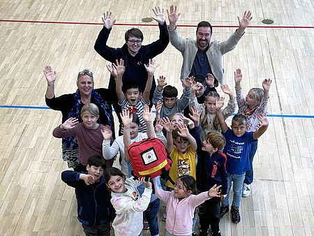 Übergabe des Erste Hilfe Rucksacks und die Kinder freuen sich