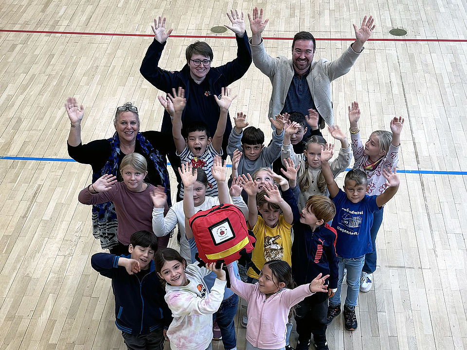 Übergabe des Erste Hilfe Rucksacks und die Kinder freuen sich
