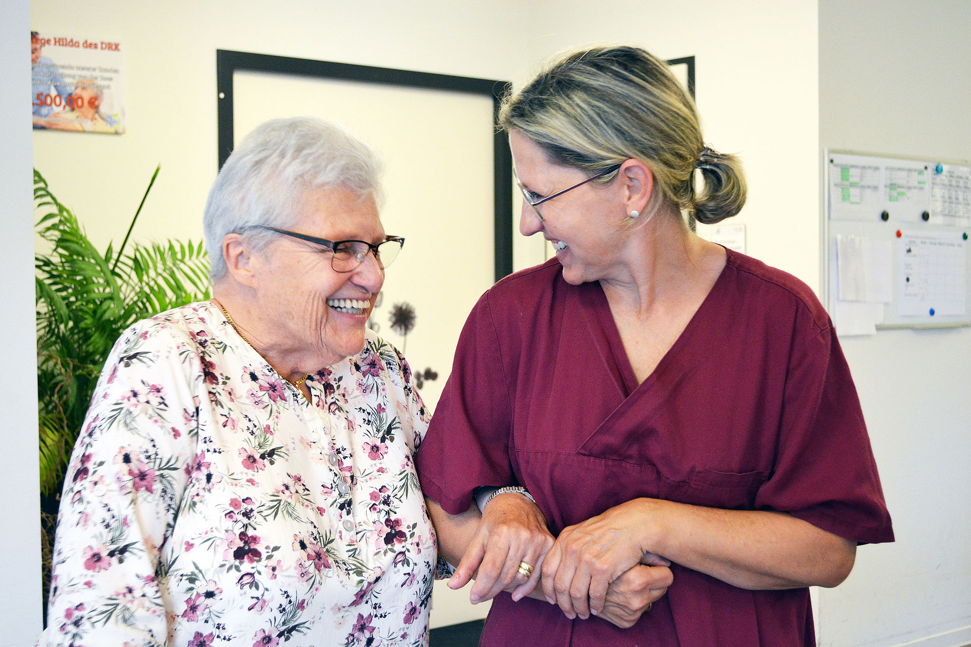 Pflegekraft und Gast in der Tagespflege freuen sich