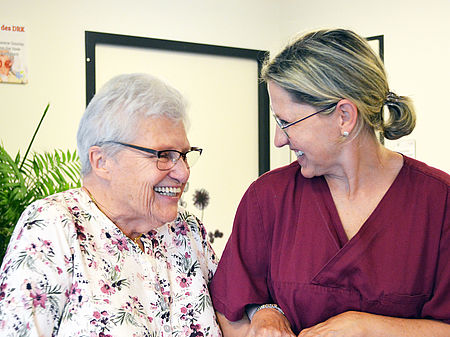Pflegekraft und Gast in der Tagespflege freuen sich