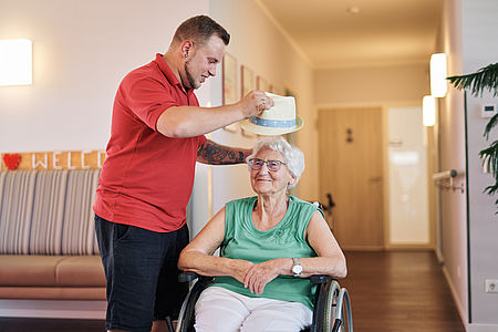 Pfleger setzt Seniorin einen Hut auf