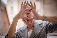 Seniorin formt ein Herz aus ihren Fingern vor ihrem Gesicht